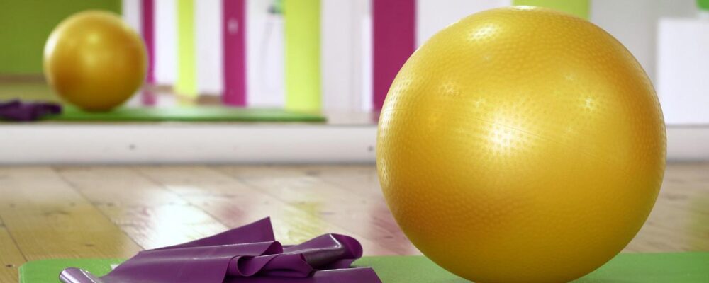 yellow Pilates ball on green mat